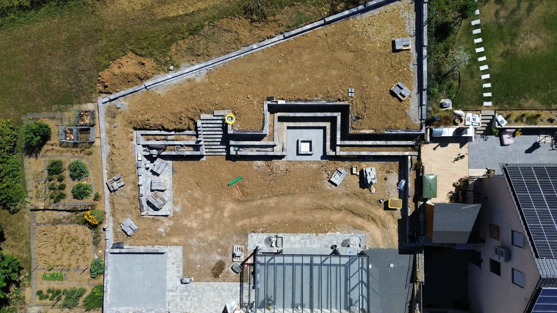 Blick von oben auf die handwerkliche Umsetzung einer Außenanlage mit Mauern und Treppen