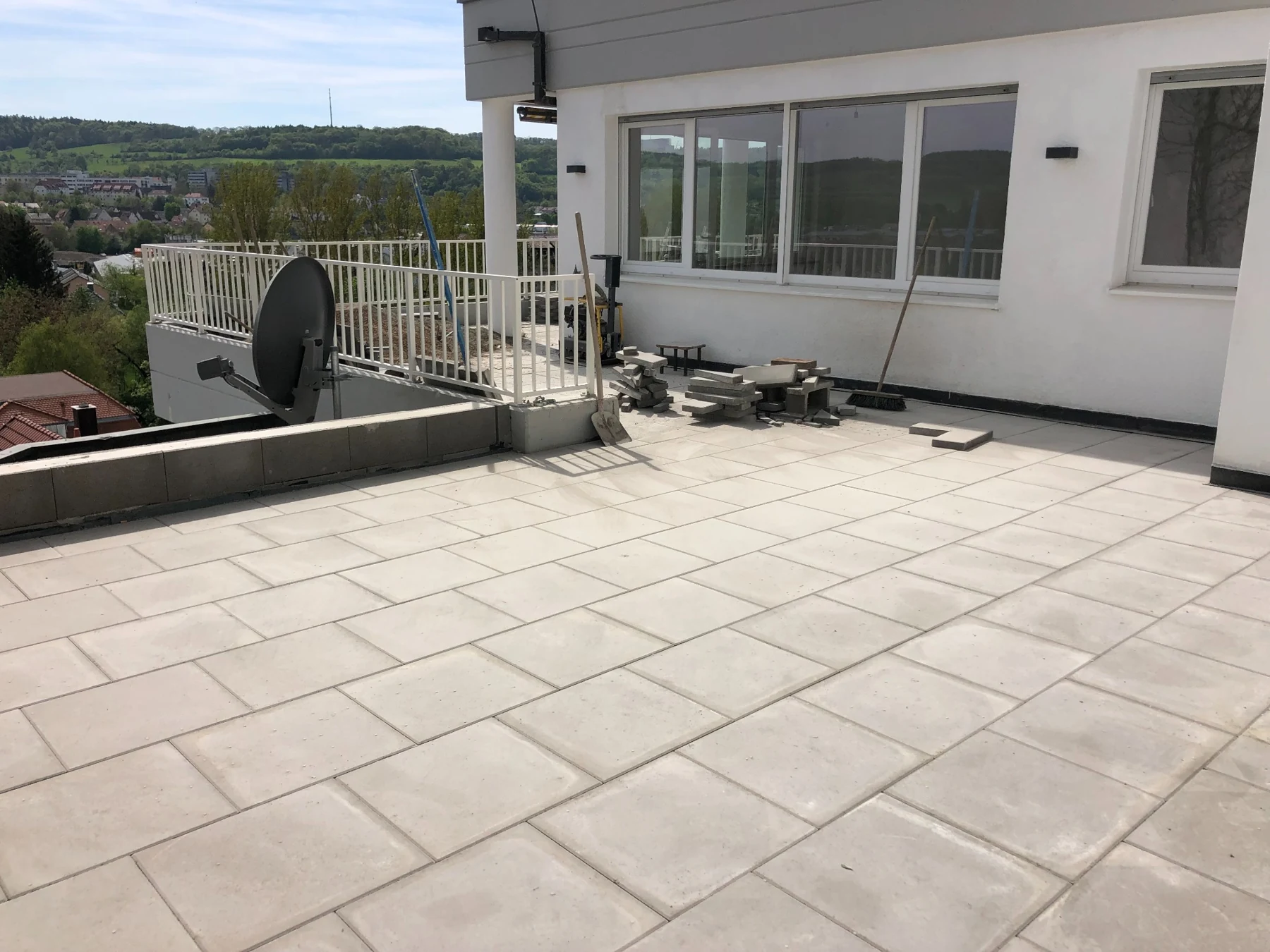 Helle großformatige Terrassenplatten vor einer Hausfassade